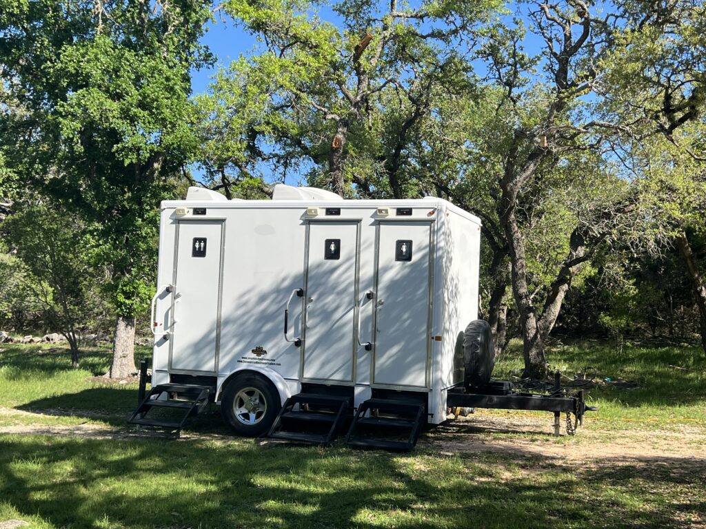Luxury restroom trailer with white exterior at outdoor wedding in Franklin TN